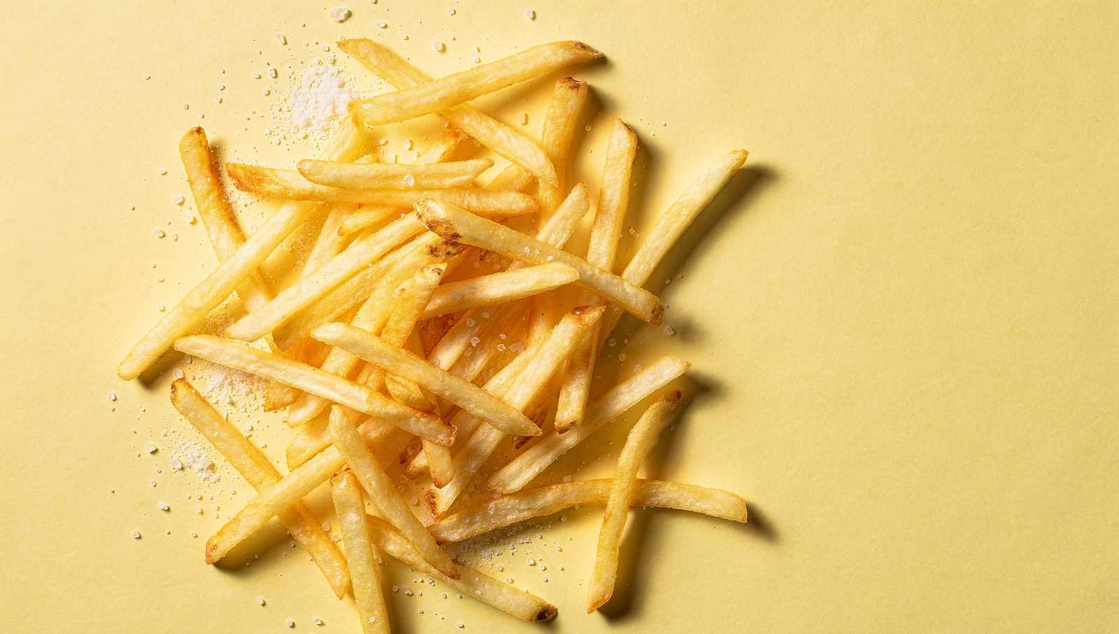 Golden French fries on a bright cream background