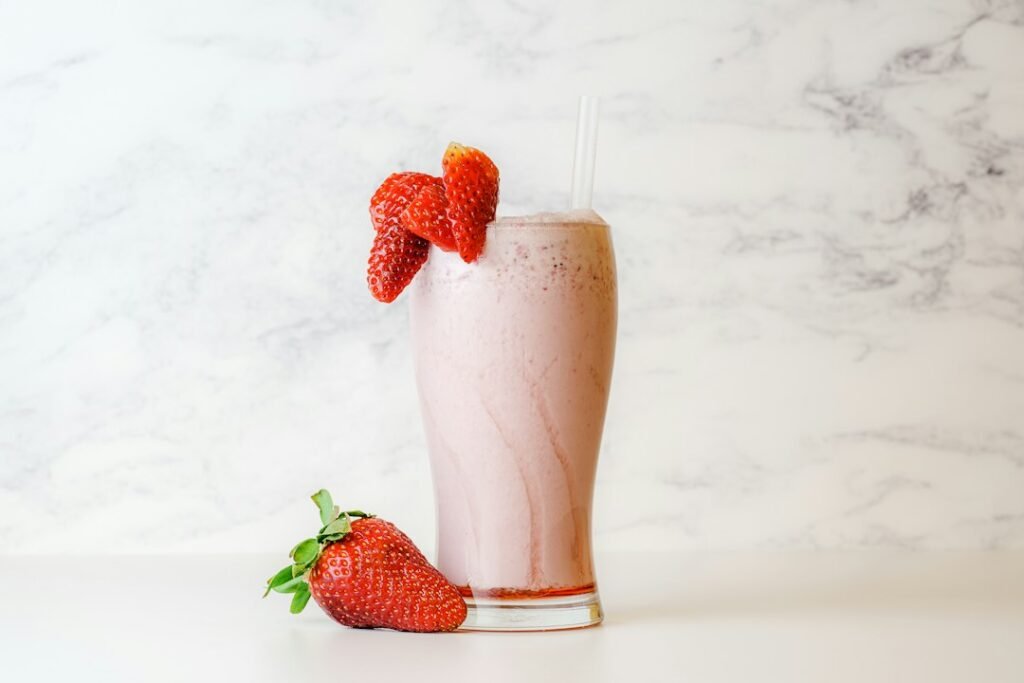 Strawberry milkshake with a fresh strawberry garnish